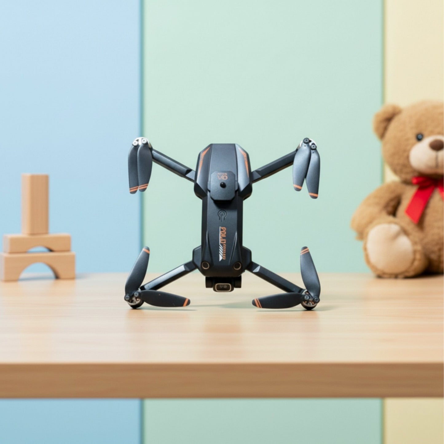 Black drone on a wooden surface with a teddy bear and building blocks in the background